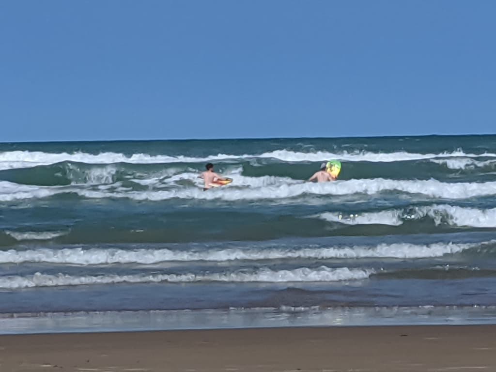 Kids playing and jumping waves in the Gulf surf on South Padre Island
